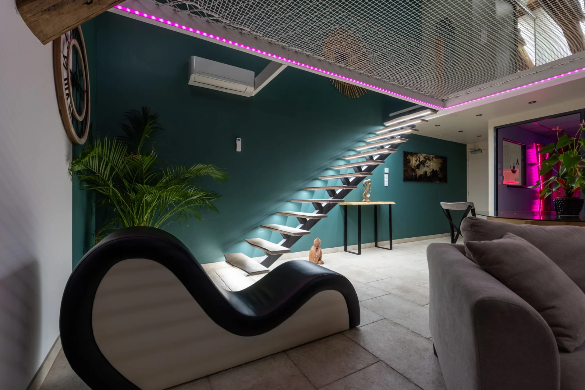 Salon du Loft Kiss avec escalier et filet suspendu chez Espace Évasions à Toulouse