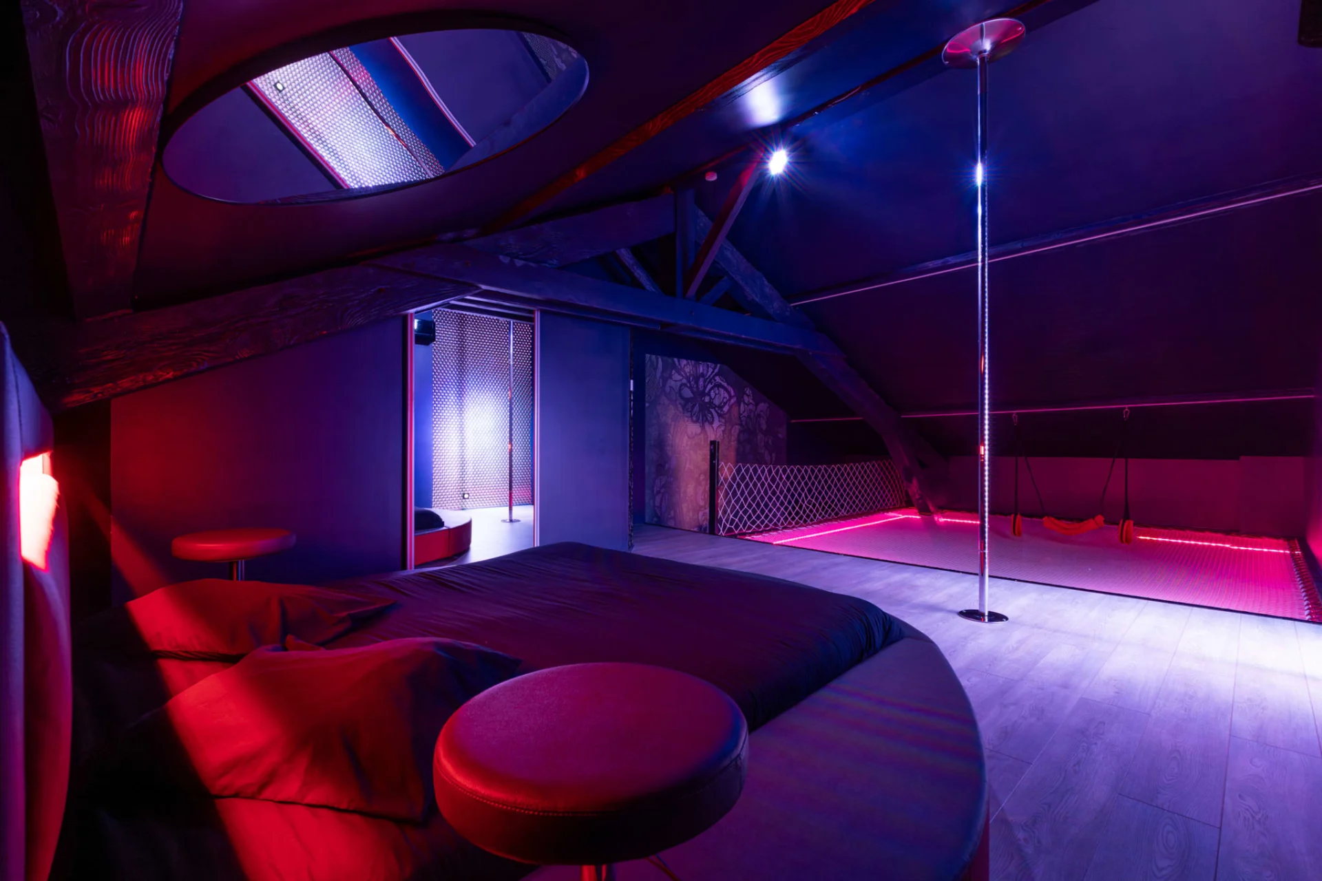 Chambre du Loft Love avec lit rond et barre de pole dance chez Espace Évasions à Toulouse
